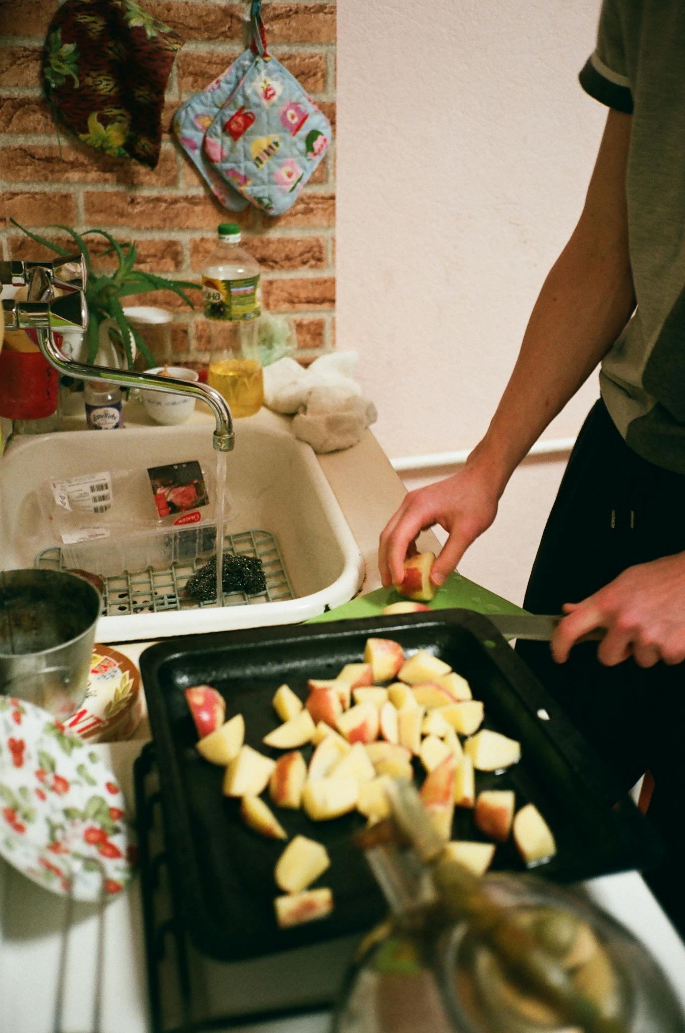 A person slicing apples in a cozy kitchen setting, emphasizing home cooking.